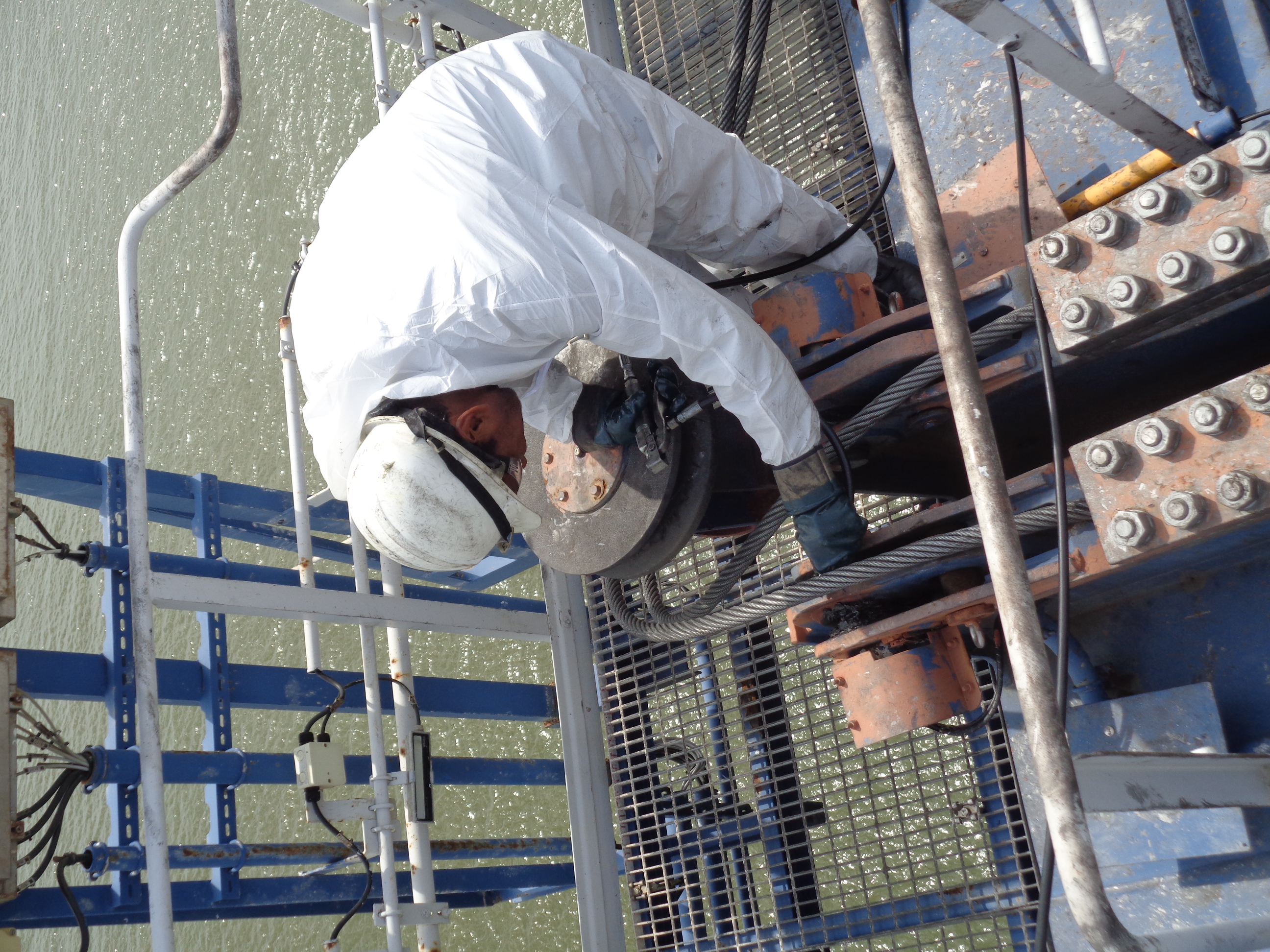 Técnico Mecaport inspeccionando sistema de cables de grúa pórtico sobre el mar en Cartagena